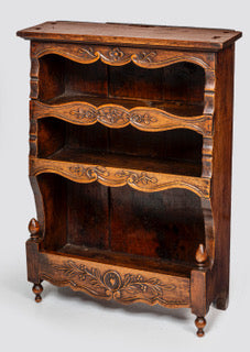 A antique 19th century French carved oak free standing spice rack, decorated with carved foliage on the front