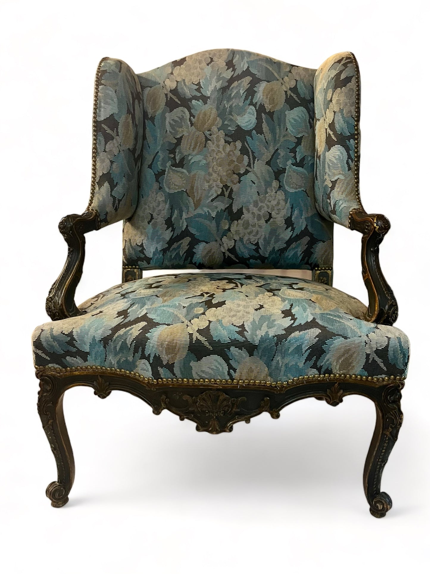 A antique 19th century French parcel gilt winged back arm chair, supported by 4 carved