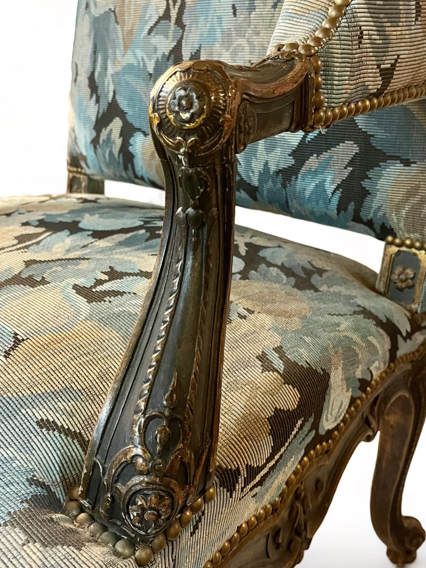 A antique 19th century French parcel gilt winged back arm chair, supported by 4 carved