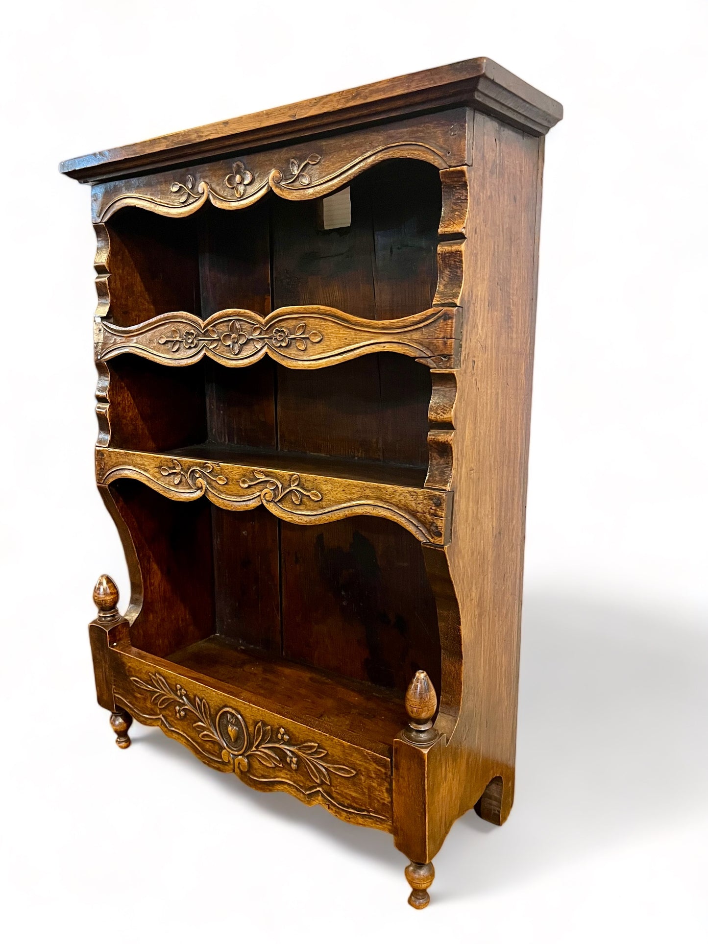 A antique 19th century French carved oak free standing spice rack, decorated with carved foliage on the front