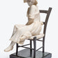 French carved Carrara marble figure of a young maiden seated in a bronze ladder back chair